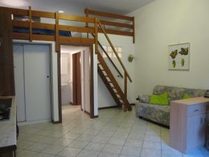 a living room with a couch and a staircase at Appartamento Pineta in Grado