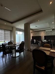 a restaurant with tables and chairs in a room at The Palms by Eagles Airport Residential in Accra