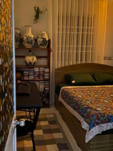 a bedroom with a bed and a table and vases at PHẠM Homestay Ca Mau in Thới Bình