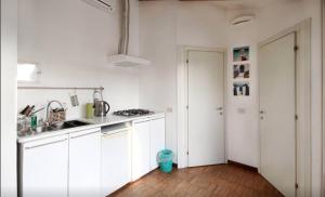 uma cozinha branca com armários brancos e piso de madeira em dHomes - Apartments and Rooms - Duomo Delight, terrace em Milão