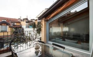 uma varanda com uma grande janela e vista para um edifício em dHomes - Apartments and Rooms - Duomo Delight, terrace em Milão