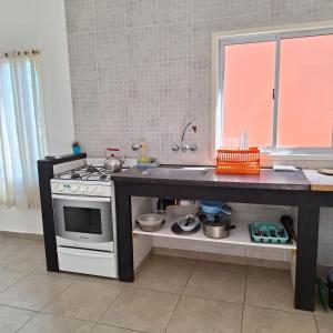 a kitchen with a counter with a stove and a sink at Bruna de Mar in Mar de Ajó +49 photos