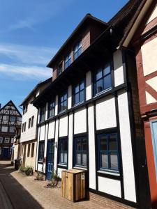 a white and black building on a street at Ferienhaus WeserLiebe in Bodenwerder