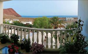 a balcony with potted plants and a view of the ocean at Magic view facing MontanaRoja in La Tejita