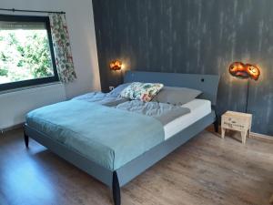 a bed in a bedroom with two lamps and a window at Ferienhaus WeserLiebe in Bodenwerder