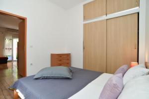Un dormitorio con una cama y un armario de madera. en Cozy apartment with shared pool, en Valbandon 17 fotos más