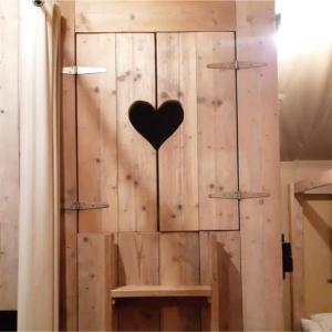 a heart hanging on a wooden wall in a room at Glampingtent 6 persoons Lindershoeve Bergeijk in Bergeijk