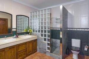 a bathroom with two sinks and a toilet at Villa Santa Ana en La Carlota in La Carlota +29 photos