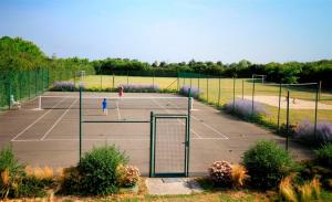 two people playing tennis on a tennis court at Glamping Vendée in Saint-Julien-des-Landes +28 photos