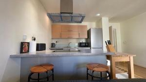 a kitchen with two bar stools and a counter top at Stratford 2 bedroom Apartment with 2 Bathrooms & Great Links in London