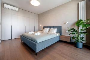 a bedroom with a bed and a potted plant at Premium Suite, RIVER & OLD TOWN VIEW,FREE PARKING in Bratislava
