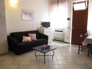 ein Wohnzimmer mit einem Sofa und einem Tisch in der Unterkunft Appartamento Pineta in Grado