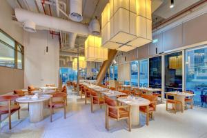ドバイにあるRoyal Regency Suites Marinaのテーブルと椅子、シャンデリアのあるレストラン