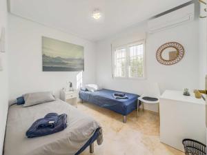 Un dormitorio con una cama y un escritorio y una ventana. en Apartment in holiday community with shared pool, en Orihuela 7 fotos más