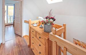 a room with a wooden dresser with a vase of flowers on it at Ferienhaus Ostseebad Breege in Breege +11 photos