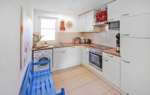 a kitchen with white cabinets and a blue chair in it at Ferienhaus Ostseebad Breege in Breege