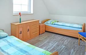 a bedroom with two beds and a dresser and a window at Ferienwohnung Feldberger in Conow