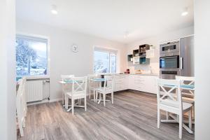 a kitchen with white cabinets and a table and chairs at Nordurey Guesthouse in Reykjavík