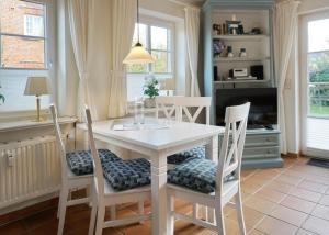 a dining room with a white table and chairs at Fewo Arnfried Whg 5 in Wenningstedt