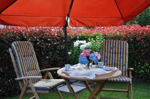 einen Tisch mit 2 Stühlen und einem Sonnenschirm in der Unterkunft Ferienwohnung an der Allee in Bad Zwischenahn