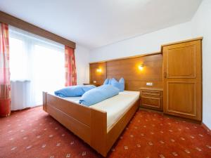 sypialnia z dużym łóżkiem i niebieskimi poduszkami w obiekcie Holiday Home Kleewein by Interhome w Solden