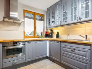 a kitchen with gray cabinets and a sink at Apartment Fer à Cheval-3 by Interhome in Châtel