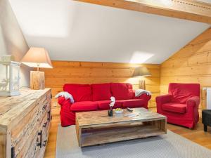 a living room with red couches and a coffee table at Apartment Fer à Cheval-3 by Interhome in Châtel