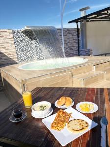 a table with plates of food on a table with a hot tub at Dadison Plaza Hotel in Piedecuesta