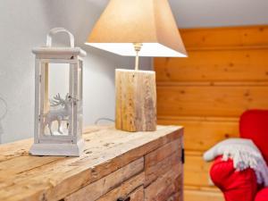 a table with a lamp and a picture of a deer in a lantern at Apartment Fer à Cheval-3 by Interhome in Châtel