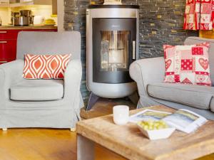 een woonkamer met twee stoelen en een open haard bij Apartment Fer à Cheval-2 by Interhome in Châtel