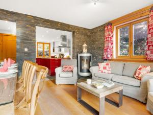 een woonkamer met een bank en een tafel bij Apartment Fer à Cheval-2 by Interhome in Châtel