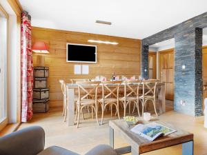 een eetkamer met een tafel en een tv bij Apartment Fer à Cheval-2 by Interhome in Châtel +24 foto's