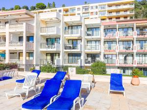 a row of blue lounge chairs in front of a building at Apartment L'Ange Gardien-2 by Interhome in Beaulieu-sur-Mer