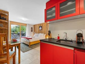 een keuken met rode kasten en een woonkamer bij Apartment Rütschi-1 by Interhome in Zermatt