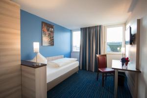 ein Hotelzimmer mit einem Bett und einem Schreibtisch in der Unterkunft Motel 44 in Geseke