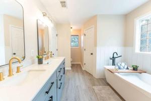 a bathroom with two sinks and a large mirror at 15 Min to UA Private Heated Pool Huge Yard Luxe Master in Tuscaloosa