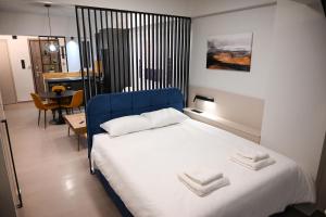 Un dormitorio con una cama azul con toallas. en GMluxuryapartments, en Larisa