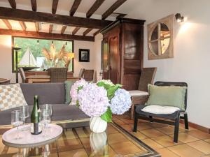 a living room with a couch and a table with flowers at Holiday Home Etoile de Mer by Interhome in Erquy +17 photos