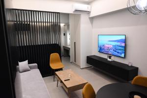 Una sala de estar con un sofá y un televisor en una pared. en GMluxuryapartments, en Larisa