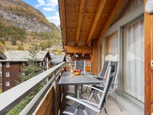 ツェルマットにあるApartment Rütschi-6 by Interhomeの家の上にテーブルと椅子付きのバルコニー