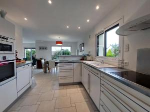 a large kitchen with white cabinets and a large window at Holiday Home Golf de Bretagne by Interhome in Sarzeau