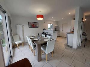a dining room and kitchen with a table and chairs at Holiday Home Golf de Bretagne by Interhome in Sarzeau