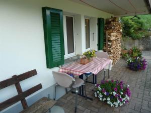 a patio with a table and chairs and flowers at Apartment Bach by Interhome in Lenk