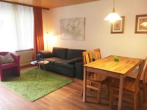 a living room with a couch and a table at Apartment Blumenweg 8 by Interhome in Engelberg +1 photo