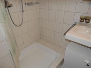 a white bathroom with a shower and a sink at Apartment Blumenweg 8 by Interhome in Engelberg