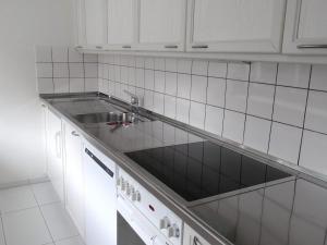 a kitchen with a sink and white cabinets at Apartment Alte Gasse 9 Wohnung 3- Stock by Interhome in Engelberg