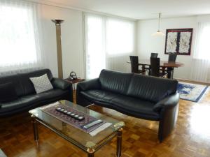 a living room with a black leather couch and a coffee table at Apartment Alte Gasse 9 Wohnung 3- Stock by Interhome in Engelberg
