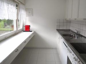 a kitchen with white cabinets and a window and a sink at Apartment Alte Gasse 9 Wohnung 3- Stock by Interhome in Engelberg +7 photos