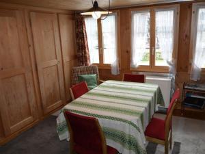 a room with a table and chairs and windows at Apartment Mittaghorn by Interhome in Gsteig