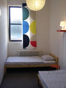 a small room with a bed and a window at Hostel Praha Ládví in Prague